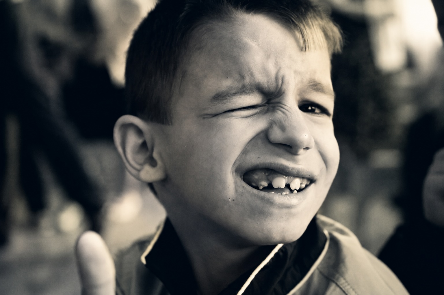 A young boy smiling and winking at the camera